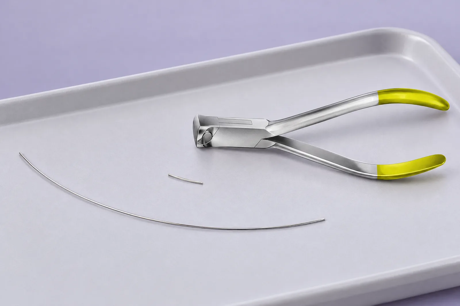 Mise en scène éditoriale générée par IA d’un coupe-fil frontal près de deux segments de fil orthodontique, sans patient