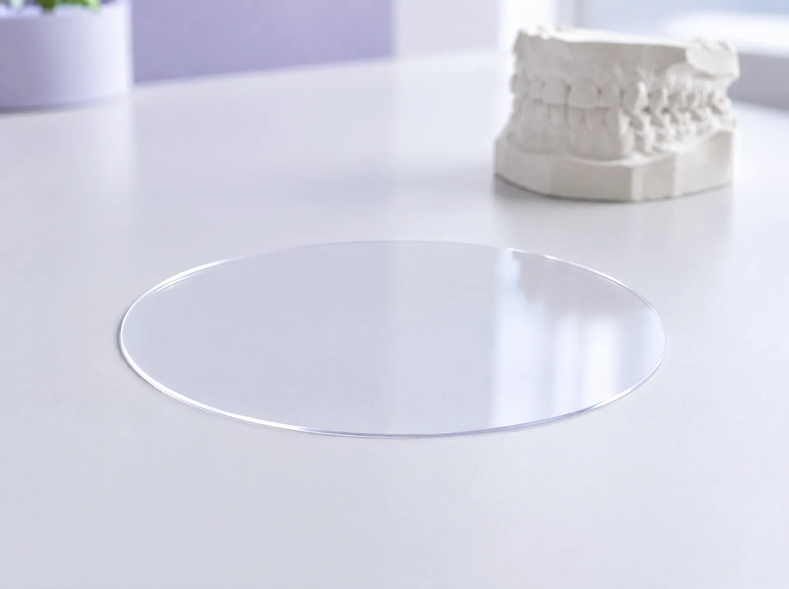 Plaque ronde transparente générique sur un plan de laboratoire dentaire, illustration éditoriale générée pour ALIGNEO